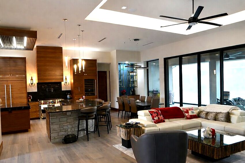 Open concept great room with kitchen, dining, and living areas in modern contemporary home - Riverside Home Designs Custom Home Portfolio