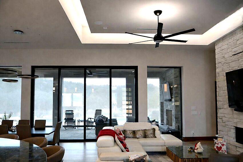 Indoor-outdoor living with large collapsible glass doors and tray ceiling - Riverside Home Designs Custom Home Portfolio
