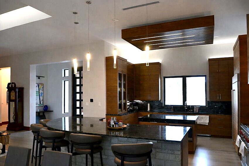 Gourmet kitchen design with walnut cabinetry, island, and wood ceiling feature - Riverside Home Designs Custom Home Portfolio